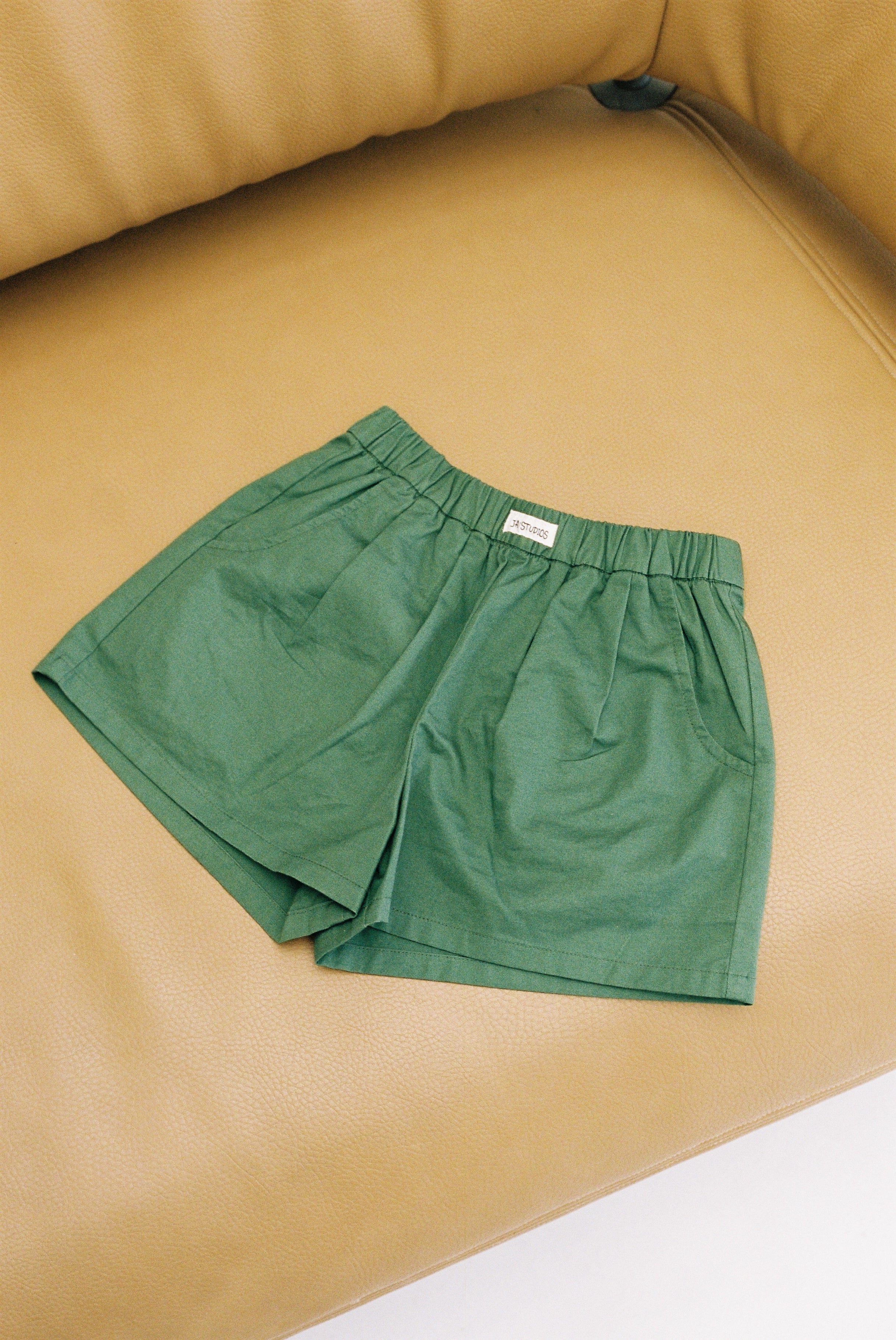 Jai Studios Forest Shorts displayed on a hanger, featuring a green camouflage pattern and casual fit for outdoor wear