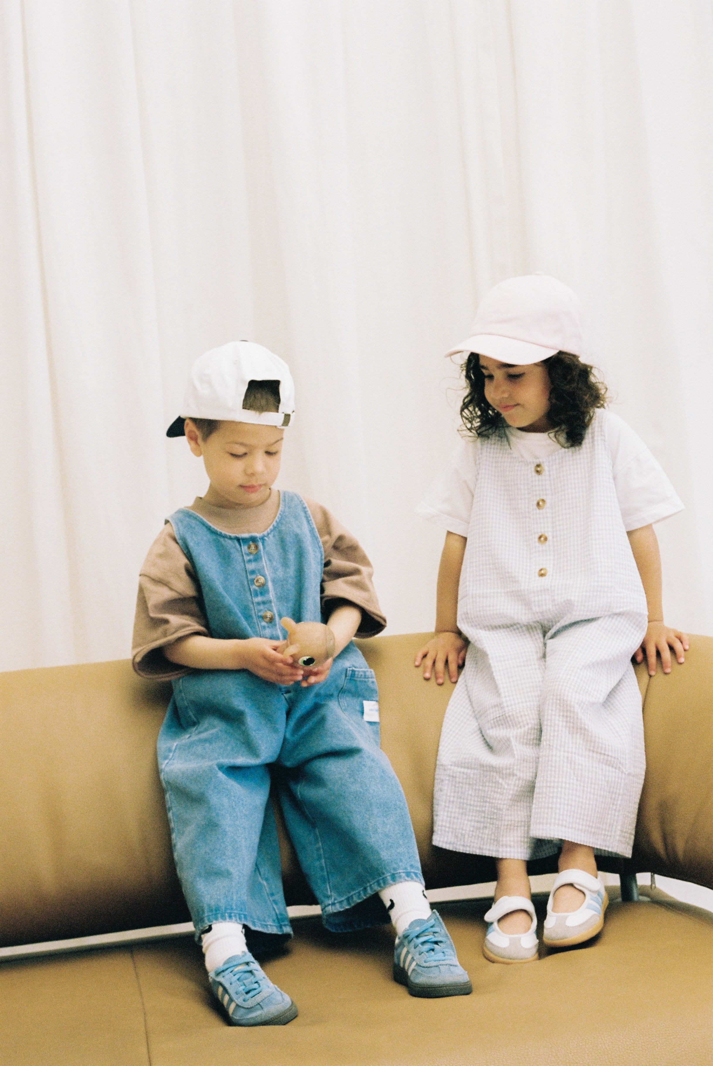Jai Studios Lumi Overalls featuring a fitted design, adjustable straps, and a light denim wash, displayed on a mannequin.