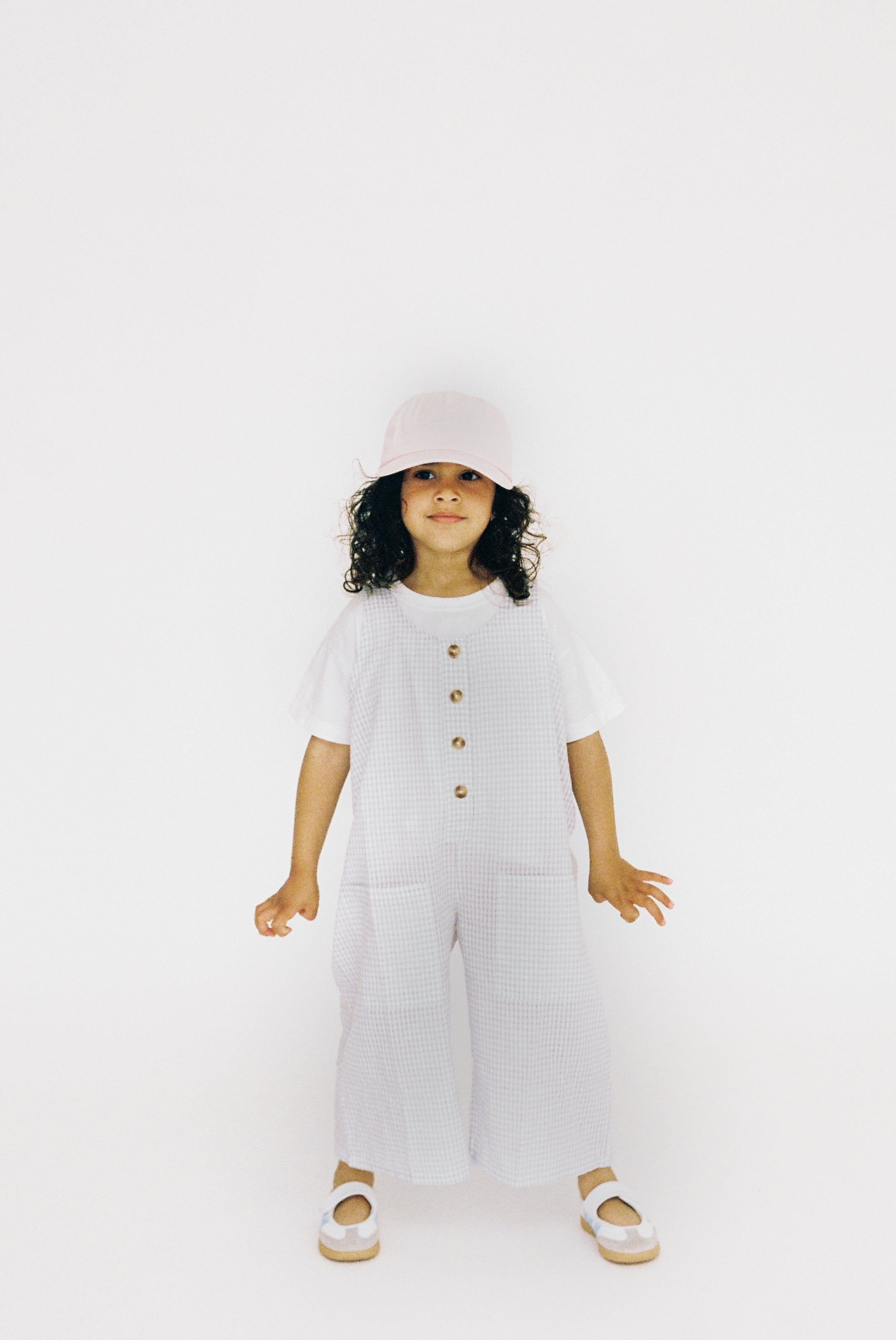 Jai Studios Lumi Overalls in neutral fabric, featuring adjustable straps and front pockets, shown on a model.