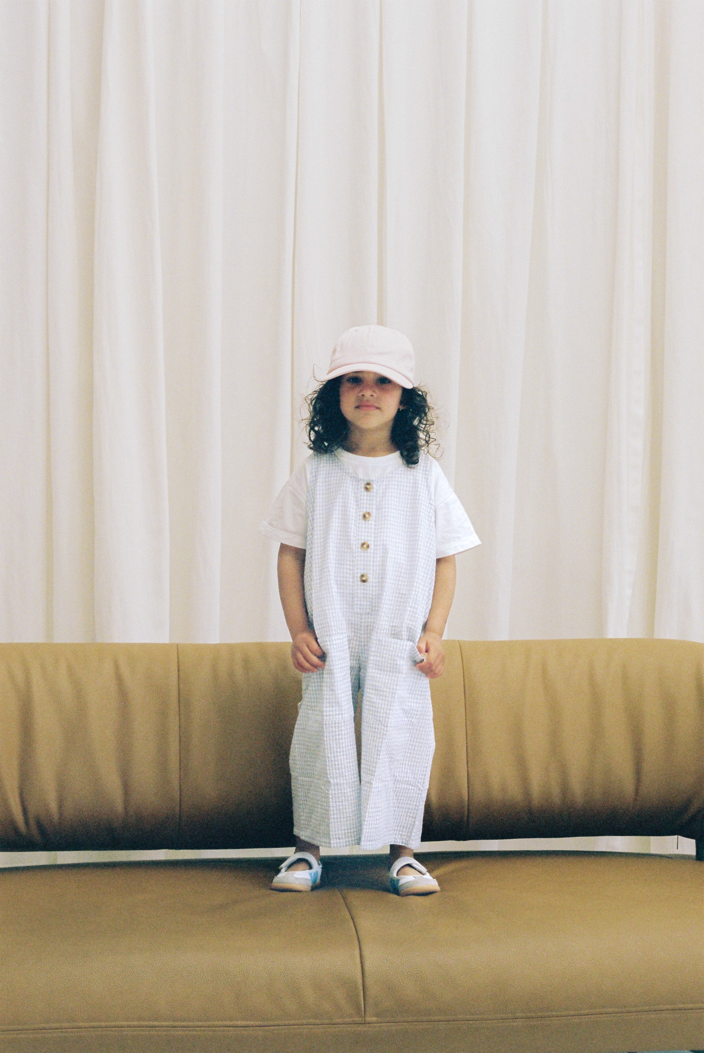 Jai Studios Lumi overalls with adjustable straps, front pockets, and a relaxed fit, shown on a model in a casual studio setting.